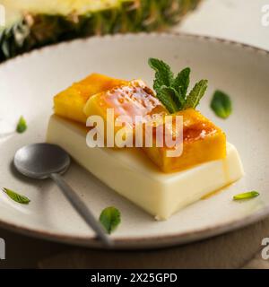 Panna cotta italiana con ananas caramellato. Foto Stock