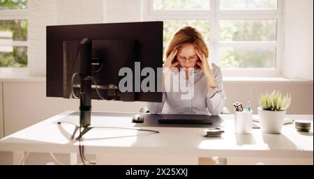 Donna dipendente malata stressata al computer in ufficio Foto Stock