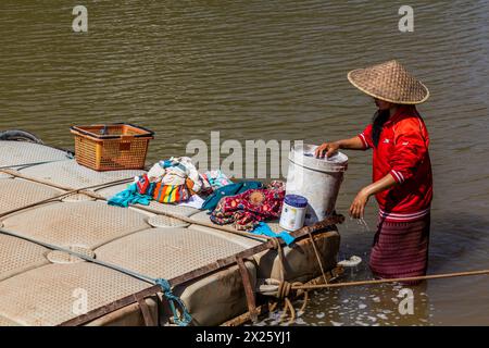 MUANG NGOI NEUA, LAOS - 25 NOVEMBRE 2019: Donna locale che fa il bucato nel fiume Nam Ou nel villaggio di Muang Ngoi Neua, Laos Foto Stock