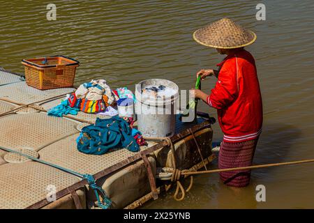 MUANG NGOI NEUA, LAOS - 25 NOVEMBRE 2019: Donna locale che fa il bucato nel fiume Nam Ou nel villaggio di Muang Ngoi Neua, Laos Foto Stock