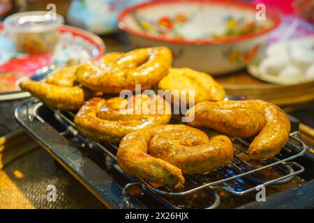 Immergetevi nei sapori della Thailandia settentrionale con questa saporita delizia! Salsicce aromatiche alla griglia, rinomate per la loro miscela unica di spezie e ricca fla Foto Stock