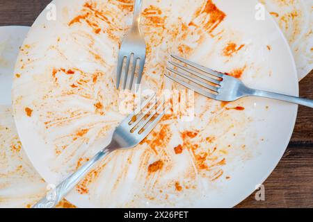 piatti sporchi dopo aver mangiato. Posate. forche su una piastra. Piatti sporchi dopo aver mangiato. Fine del pasto. Buon appetito, cibo delizioso e concetto di piatto Foto Stock