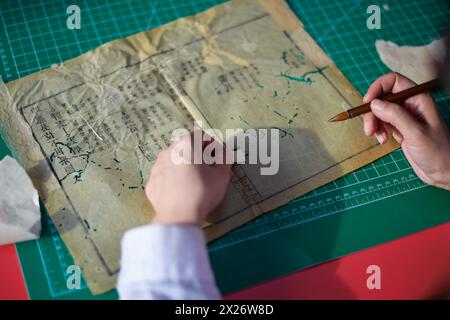 (240420) -- CHANGCHUN, 20 aprile 2024 (Xinhua) -- Zhang Hua, un restauratore di libri antichi nella biblioteca dell'Università di Jilin, muta le pagine di un libro antico nella biblioteca dell'Università di Jilin a Changchun, nella provincia di Jilin, nella Cina nord-orientale, 19 aprile 2024. La Jilin University vanta una collezione di quasi 400.000 libri antichi nella sua biblioteca. Secondo Zhang Qi, un restauratore di libri antichi nella biblioteca dell'Università di Jilin, la scuola ha eseguito i lavori di restauro di libri antichi fin dagli anni '1950, che non è mai stato interrotto per decenni. Generazioni di antiche rievocazioni di libri Foto Stock