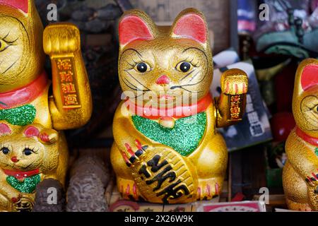 Chongqing, provincia di Chongqing, souvenirs, stall, on the Yangtze, figure Maneki-neko dorate, fascino della fortuna giapponese a forma di gatti ondeggianti Foto Stock