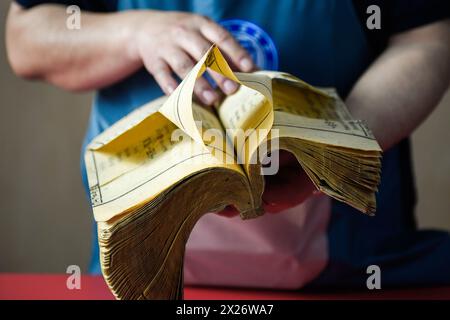 (240420) -- CHANGCHUN, 20 aprile 2024 (Xinhua) -- Zhang Qi, un restauratore di libri antichi nella biblioteca dell'Università di Jilin, osserva i danni delle pagine di un libro antico prima del restauro presso la biblioteca dell'Università Jilin a Changchun, nella provincia di Jilin, nella Cina nord-orientale, 19 aprile 2024. La Jilin University vanta una collezione di quasi 400.000 libri antichi nella sua biblioteca. Secondo Zhang Qi, un restauratore di libri antichi nella biblioteca dell'Università di Jilin, la scuola ha eseguito i lavori di restauro di libri antichi fin dagli anni '1950, che non è mai stato interrotto per dieci anni Foto Stock