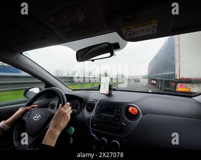 Milano, Italia - 26 aprile 2023 Vista dall'interno di un'auto con configurazione di navigazione smartphone alla guida Foto Stock