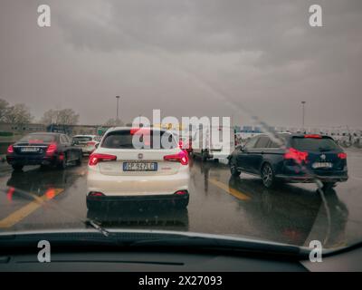 Milano, Italia - 26 aprile 2023 ingorgo commerciale in avvicinamento ad uno stand a pedaggio con un dispositivo di navigazione in primo piano, autostrada A1 Foto Stock