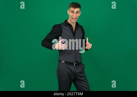 emozioni di un bell'uomo su sfondo verde cromakey primo piano capelli scuri giovane uomo. Bell'uomo che fa diverse espressioni in diversi set di vestiti Foto Stock