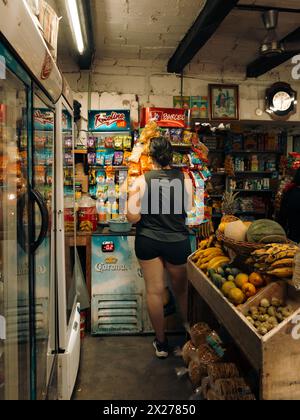 Le donne acquistano cibo, bevande e spuntini in un piccolo e affascinante mercato di strada in Messico di notte. Foto Stock