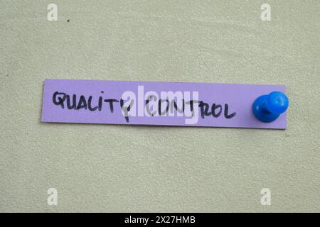 Concetto di controllo qualità scrivere su note adesive isolate su un tavolo di legno. Foto Stock