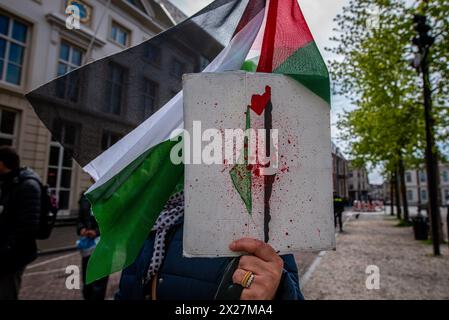 L'Aia, Olanda meridionale, Paesi Bassi. 20 aprile 2024. Un manifestante filo-palestinese ha un cartello che raffigura un profilo sanguinoso di Israele pieno di una bandiera palestinese. Il 20 aprile 2024, i manifestanti filo-palestinesi hanno marciato in solidarietà con Gaza attraverso il centro dell'Aia, nei Paesi Bassi. (Credit Image: © James Petermeier/ZUMA Press Wire) SOLO PER USO EDITORIALE! Non per USO commerciale! Crediti: ZUMA Press, Inc./Alamy Live News Foto Stock