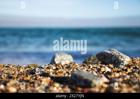 Spiaggia di Llevant, Barcellona, Spagna, in una giornata di sole, onde e mare, cielo azzurro, sabbia, ciottoli e rocce, vibrazioni estive, madre natura, felice giornata della Terra Foto Stock