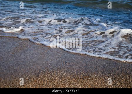 Spiaggia di Llevant, Barcellona, Spagna, in una giornata di sole, onde e mare, cielo azzurro, sabbia, ciottoli e rocce, vibrazioni estive, madre natura, felice giornata della Terra Foto Stock