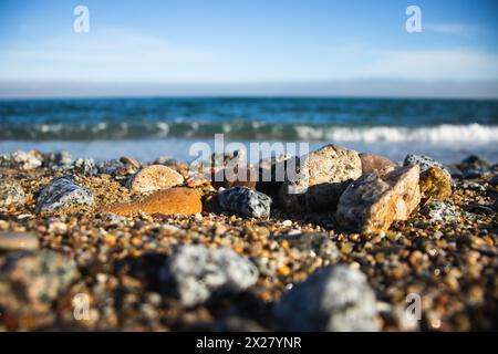 Spiaggia di Llevant, Barcellona, Spagna, in una giornata di sole, onde e mare, cielo azzurro, sabbia, ciottoli e rocce, vibrazioni estive, madre natura, felice giornata della Terra Foto Stock