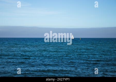 Spiaggia di Llevant, Barcellona, Spagna, in una giornata di sole, onde e mare, cielo azzurro, sabbia, ciottoli e rocce, vibrazioni estive, madre natura, felice giornata della Terra Foto Stock