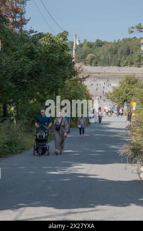 I turisti camminano su e giù per Bridge Street fino al bar di sabbia a Bar Harbor con la bassa marea. Mount dessert Island, Maine, Stati Uniti Foto Stock