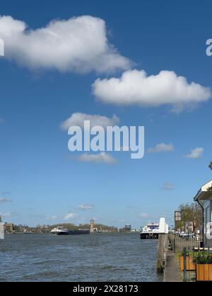 Trasporto di merci per chiatte interne navigando oltre Dordrecht in Olanda, nei Paesi Bassi, sulle calme acque del fiume Maas. Trasporto nave container Foto Stock