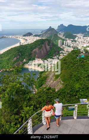 Una coppia giovane guarda la vista su Rio de Janeiro dal Pan di zucchero, Rio de Janeiro, Stato di Rio de Janeiro, Brasile. Foto Stock