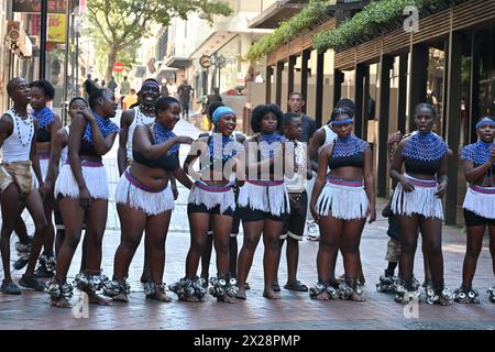 Gruppo di ragazzi e ragazze di colore in costume locale che eseguono una tipica danza africana nel centro di città del Capo, in Sudafrica Foto Stock