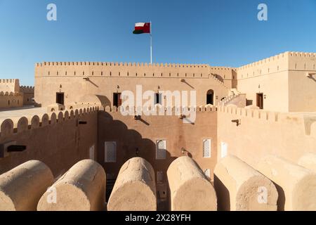 Rustaq, Oman - 14 febbraio 2023: La bandiera nazionale dell'Oman vola all'interno del castello e forte di al Hazm che risale al 1708 nella penisola araba. Foto Stock