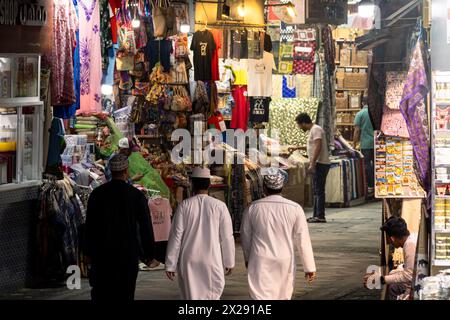 Mascate, Oman - 13 febbraio 2023: Uomini arabi che indossano il tradizionale thawb Walk attraverso il tradizionale suq Mutrah, o bazar, a Mascate, nella capitale dell'Oman Foto Stock