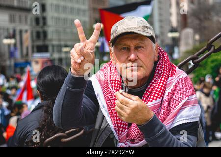 Chicago, Stati Uniti, 20 aprile 2024, l'uomo mostra un segno di pace mentre i manifestanti della Pro Palestina marciano per le strade del centro di Chicago per protestare contro l'occupazione israeliana di Gaza, affinché Joe Biden ponga fine ai finanziamenti statunitensi di Israele e chieda un cessate il fuoco, credito: David Jank/Alamy Live News Foto Stock