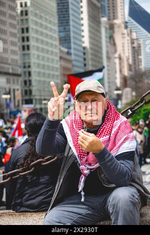 Chicago, Stati Uniti, 20 aprile 2024, l'uomo mostra un segno di pace mentre i manifestanti della Pro Palestina marciano per le strade del centro di Chicago per protestare contro l'occupazione israeliana di Gaza, affinché Joe Biden ponga fine ai finanziamenti statunitensi di Israele e chieda un cessate il fuoco, credito: David Jank/Alamy Live News Foto Stock