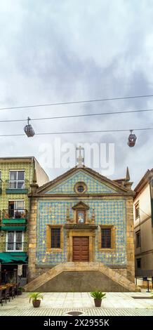 Cappella di nostra Signora della Misericordia a Vila Nova de Gaia, decorata con piastrelle, con due gondole della funivia di Gaia che passa sopra la croce cristiana e Foto Stock