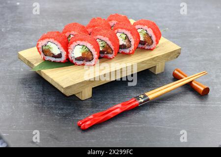 Consegna di sushi. Set di rotoli in una scatola monouso su sfondo nero. Vista dall'alto, Foto Stock