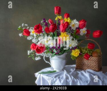 Natura morta con bouquet di fiori e cestino di frutta Foto Stock