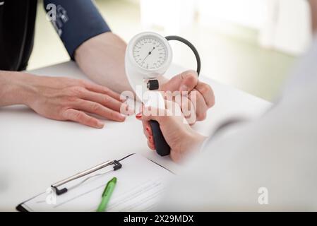 Un esperto medico si concentra sulla scrittura delle informazioni vitali in un ambiente clinico. Foto Stock