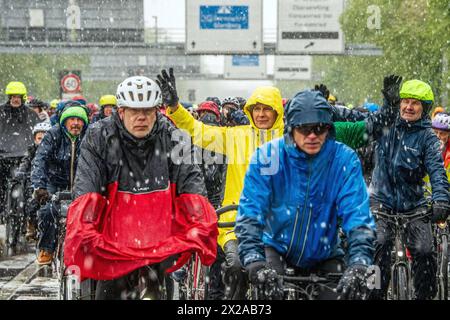 Rad-Sternfahrt des ADFC, Teilstück über die Autobahn A95, München, 21. Aprile 2024 Deutschland, München, 21. Aprile 2024, große Rad-Sternfahrt des ADFC, hier bei Schneefall auf der gesperrten Autobahn A 95 bei München-Sendling, alle in Regenjacken eingehüllt und durchnässt, fahren stadteinwärts Richtung Luise-Kiesselbach-Platz, kehren um und fahren auf der Gegenseite Zurück Richtung Ausfahrt für München gemeinsam Radeln für eine bessere Radinfrastruktur, Teilstück über die A95, Verkehr, Fahrrad fah Foto Stock