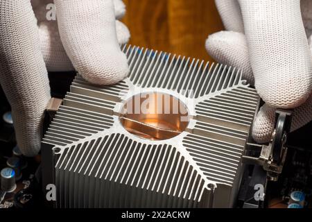 Un addetto all'assistenza che monta un dissipatore di calore passivo raffreddato ad aria sulla CPU del computer Foto Stock