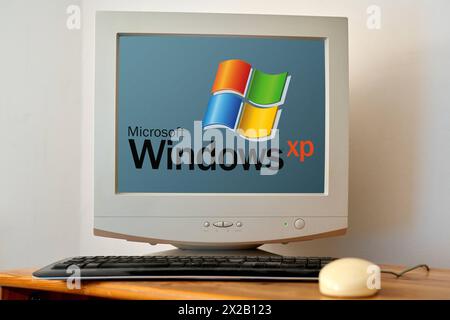 21 aprile 2024: Vecchio computer su una scrivania con uno schermo che mostra il logo di Microsoft Windows XP. FOTOMONTAGGIO *** alter computer auf einem Schreibtisch mit Bildschirm auf dem das Microsoft Windows XP Logo zu sehen ist. FOTOMONTAGE Foto Stock