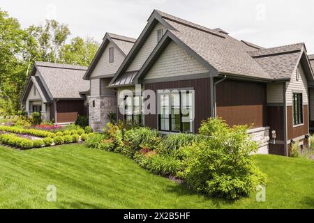 Contemporaneo pietra naturale e legno marroni e ciottoli di cedro rivestiti in lussuosa facciata casalinga in stile bungalow in estate, Quebec, Canada, Nord America Foto Stock