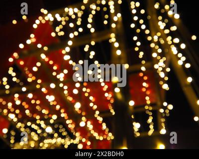 Bokeh la sera di Natale. Bellissimi bokeh rotondi. Rosso, giallo, oro, bianco al buio. Le feste fanno da sfondo per il nuovo anno, buon Natale Foto Stock