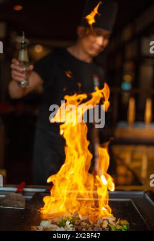 Berlino, Germania 08. 16. 2023. Chef Teppanyaki che cucina al teppan in una Steakhouse giapponese. Lo chef giapponese mostra uno spettacolo con il fuoco e prepara il flamb Foto Stock