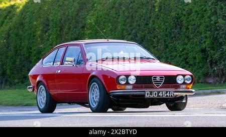 Bicester, Regno Unito - 21 aprile 2024: 1976 Alfa Romeo rossa, auto d'epoca che guida su una strada britannica Foto Stock