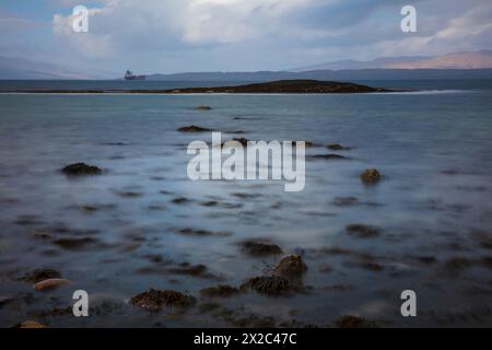 Vista sul mare attraverso Ganavan Bay con l'isola di Mull in lontananza. Oban, Argyll e Bute, Scozia. Foto Stock