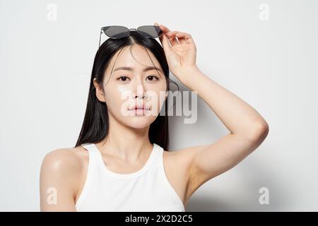 Una donna asiatica che guarda dritto avanti senza i suoi occhiali da sole Foto Stock
