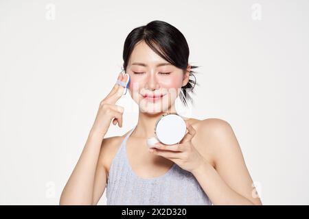 Donna asiatica che mette i fatti del cuscino sul suo viso Foto Stock