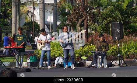 Un gruppo di adolescenti che suonano strumenti musicali e cantano canzoni per intrattenere i visitatori al Car Free Day Malang Foto Stock