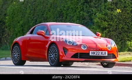 Bicester, Regno Unito - 21 aprile 2024: 2022 Alpine A110 auto d'epoca arancione che guida su una strada britannica Foto Stock