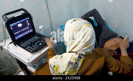 Medico donna che esegue una scansione ecografica per una donna incinta a Bogor, Giava Occidentale, Indonesia, il 4 dicembre 2023 Foto Stock
