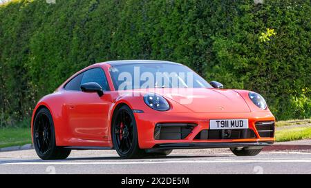 Bicester, Regno Unito - 21 aprile 2024: 2022 Porsche 911 Carrera d'epoca arancione che guida su una strada britannica Foto Stock
