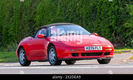 Bicester, Regno Unito - 21 aprile 2024: 1990 auto d'epoca Lotus Elan rossa che guida su una strada britannica Foto Stock