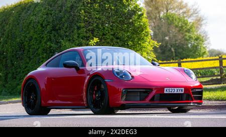 Bicester, UK- 21 aprile 2024:2023 Porsche 911 Carrera rossa, auto d'epoca che guida su una strada inglese Foto Stock