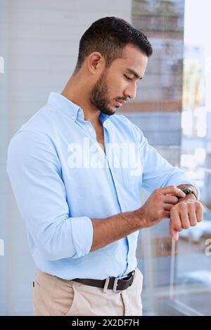 Uomo, finestra e controlla l'orario in ufficio con orologio da polso, pensiero o sveglia per promemoria all'avvio. Imprenditore, persona e vigila per il programma e la riunione Foto Stock