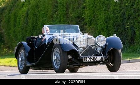 Bicester, Regno Unito - 21 aprile 2024: 2022 SUFFOLK SS100 replica della leggendaria auto sportiva a due posti Jaguar degli anni '1930 che guida su una strada britannica Foto Stock