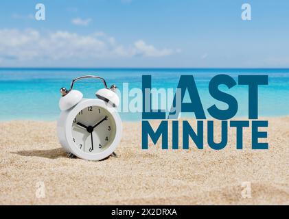 Una sveglia sulla sabbia di una spiaggia con la parola "last minute". Offerte e offerte last minute per vacanze o vacanze. Foto Stock